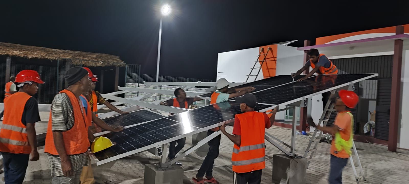 Techniciens posant des panneaux solaires sur un chantier de nuit
